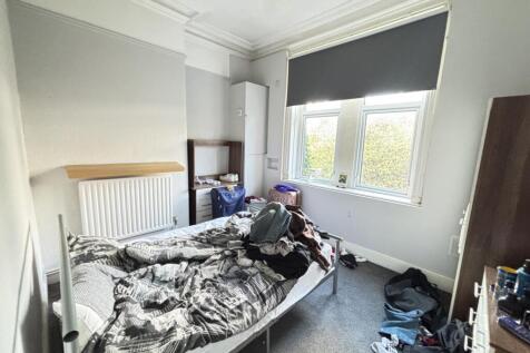 A cozy bedroom with a double bed and window pro...