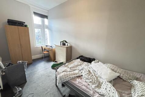 A cozy bedroom with a bed shortly made, natural...