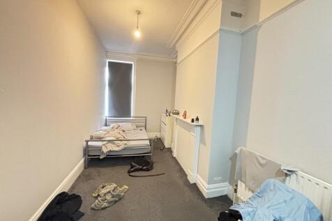 A modest bedroom with a single bed and a small ...