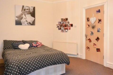 Cozy double bedroom with a patterned duvet, dec...