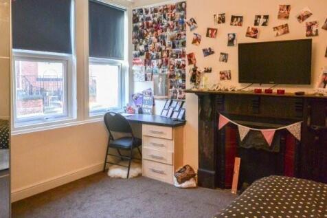 Bright, cozy bedroom with a study area by the w...