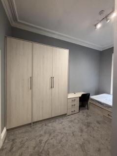 A bright and tidy bedroom featuring a large war...