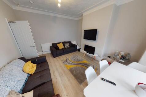 A modern, well-lit living room featuring a comf...