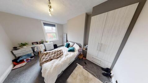 A cozy, well-lit bedroom featuring a bed, a war...