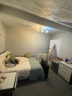 A cozy living area with a comfortable bed, some...