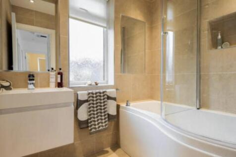 Bright modern bathroom with a curved panel bath...