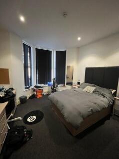 Spacious double bedroom with a large comfortabl...