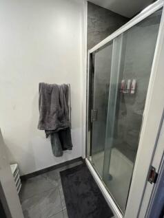 Modern bathroom with a glass-enclosed shower, s...