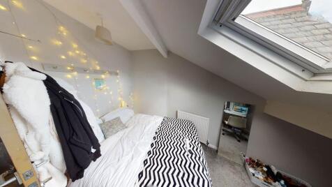 Bright angled double bedroom under a pitched ro...