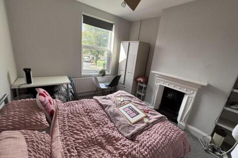 Brightly painted double bedroom with a dressed ...