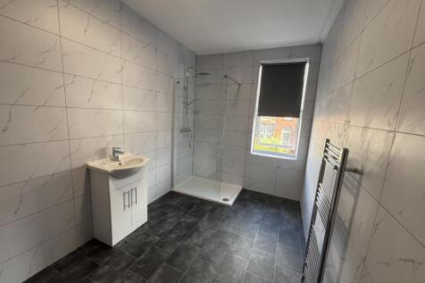 Modern tiled bathroom with a walk-in shower, wh...