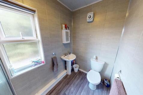 Bright, modern bathroom with a large frosted wi...