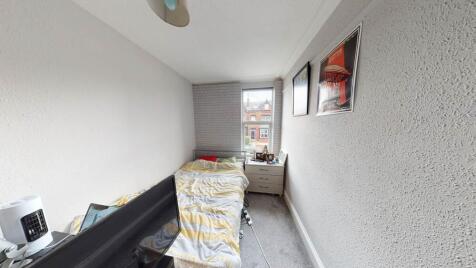 Bright narrow bedroom with a single bed positio...
