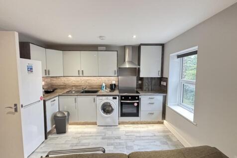Bright open-plan kitchen with modern white cabi...