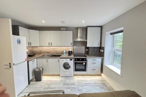 Bright, modern open-plan kitchen with integrate...