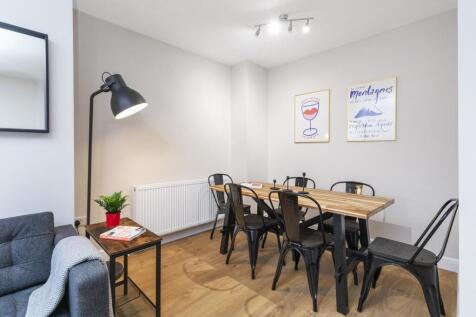 Bright, modern living/dining area with a wooden...