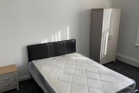 Bright, simply furnished bedroom with a double ...