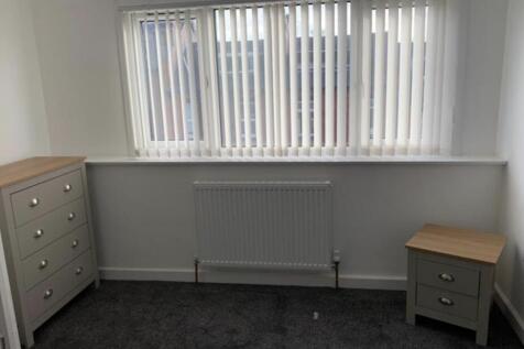 Bright, simply furnished bedroom with a large w...