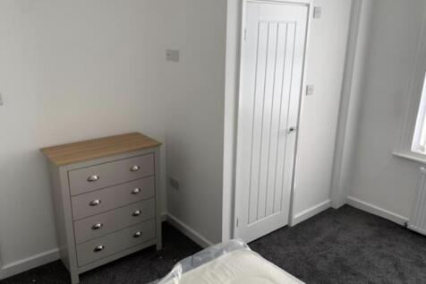 Bright, simply furnished bedroom with neutral d...