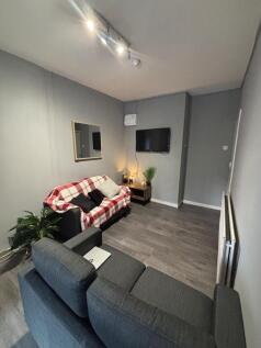 A modern, well-lit living room featuring two co...