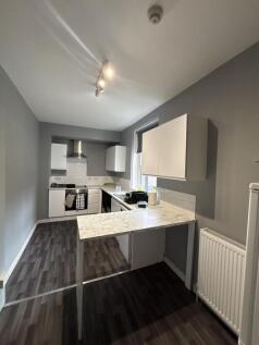 Modern kitchen area with stylish white cabinetr...