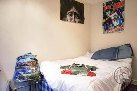 Cozy double bedroom with a neatly made bed, sof...