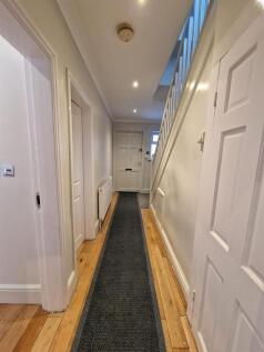 Bright, well-maintained hallway with wooden flo...