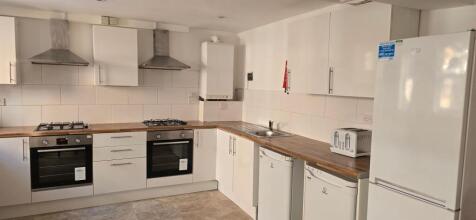 Bright, modern kitchen with matching white cabi...