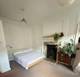 Bright, neutrally decorated bedroom with a doub...