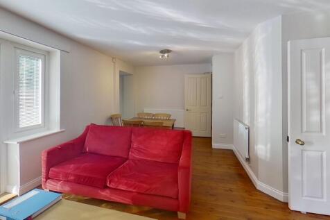 Bright, neutral living room with wooden floors,...