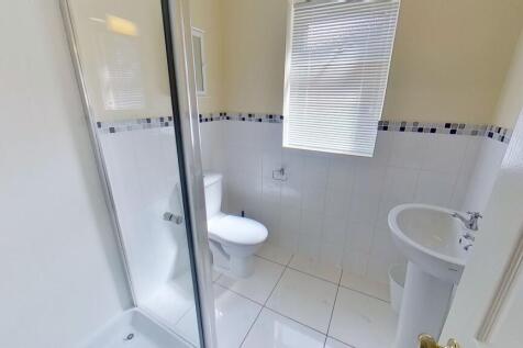 Bright, modern bathroom with a tiled shower enc...