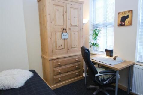 Cozy single bedroom with a wooden wardrobe, stu...