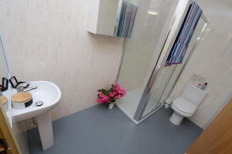 Bright, modern bathroom with a corner shower cu...