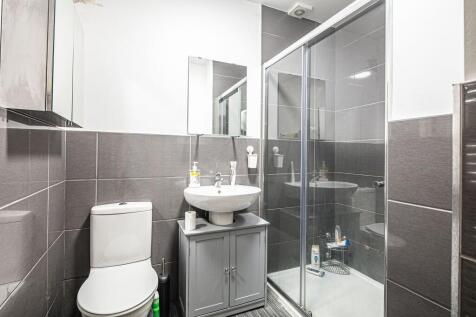 Modern tiled bathroom with a walk-in shower, pe...