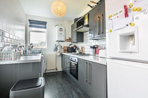 Bright modern galley kitchen with glossy grey c...