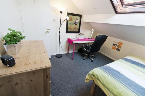 Bright, neatly furnished attic bedroom with a c...