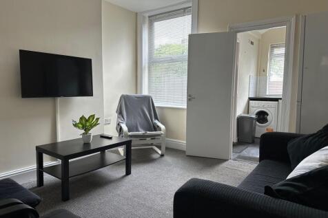 Bright, well-kept living room with a wall-mount...