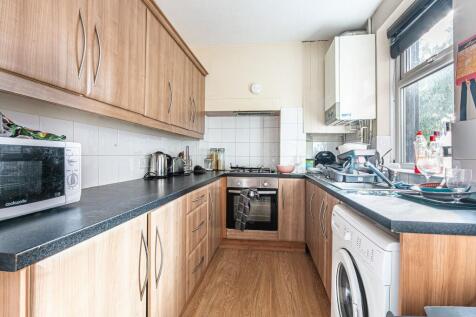 Bright galley kitchen with wood-effect cabinets...