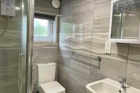 Modern tiled bathroom with a corner shower, toi...