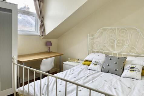Bright, neatly styled bedroom with a decorative...