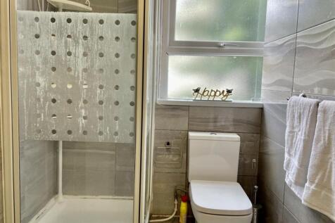 Modern bathroom with a glass-enclosed shower, f...