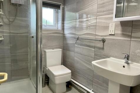 Modern tiled bathroom with a corner shower cubi...