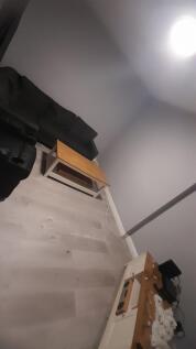 Simple, modern living area with a grey sofa, wo...