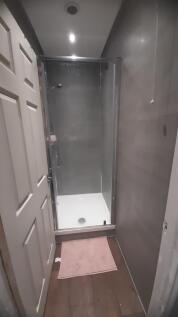 Compact modern bathroom with a walk-in shower e...