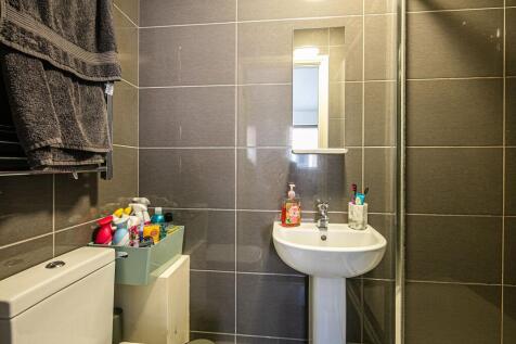 Modern tiled bathroom with a pedestal sink, mir...