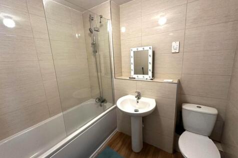 Modern tiled bathroom with a bathtub and overhe...