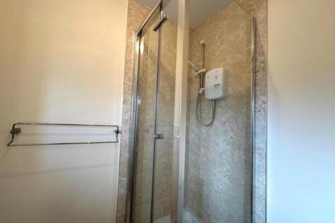 Modern shower enclosure with marble-effect tile...