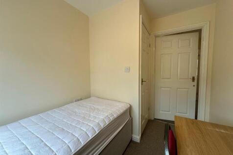 Bright, simply furnished single bedroom with a ...
