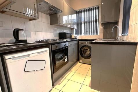 Modern galley kitchen with grey gloss cabinets,...