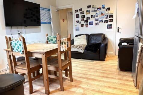 Bright, well-kept communal lounge with a wooden...